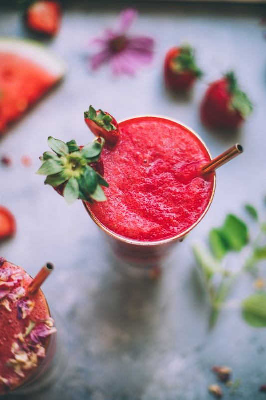 Homemade fresh strawberry agua fresca mocktail overhead view with stainless steel straw.