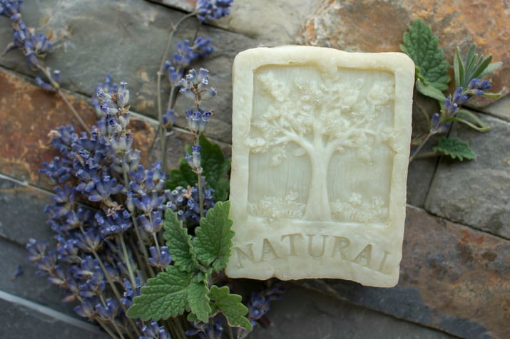 Natural homemade soap made laying with fresh herbs on bricks