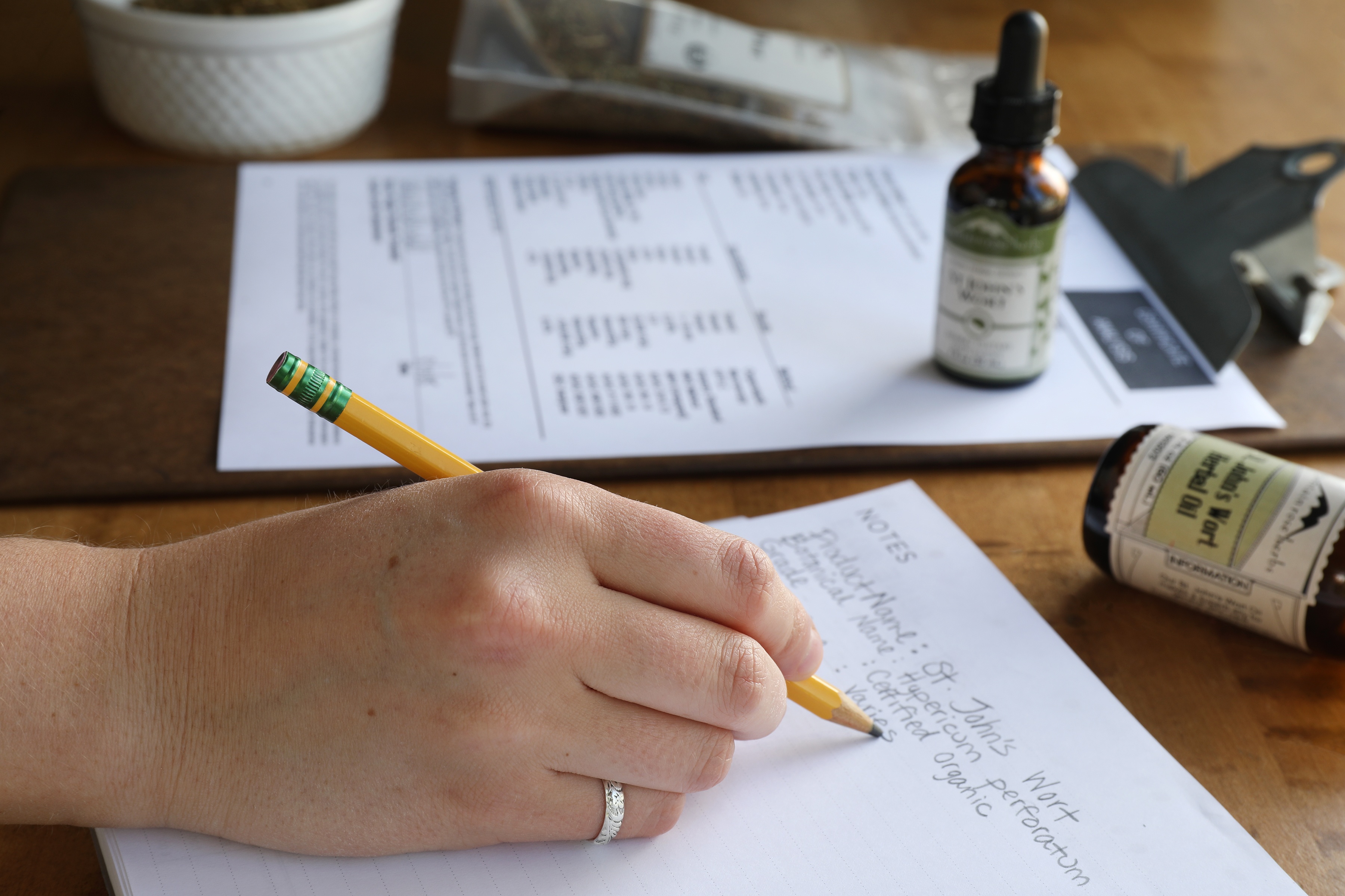 Hand holding pencil writing notes about Certificate of Analysis