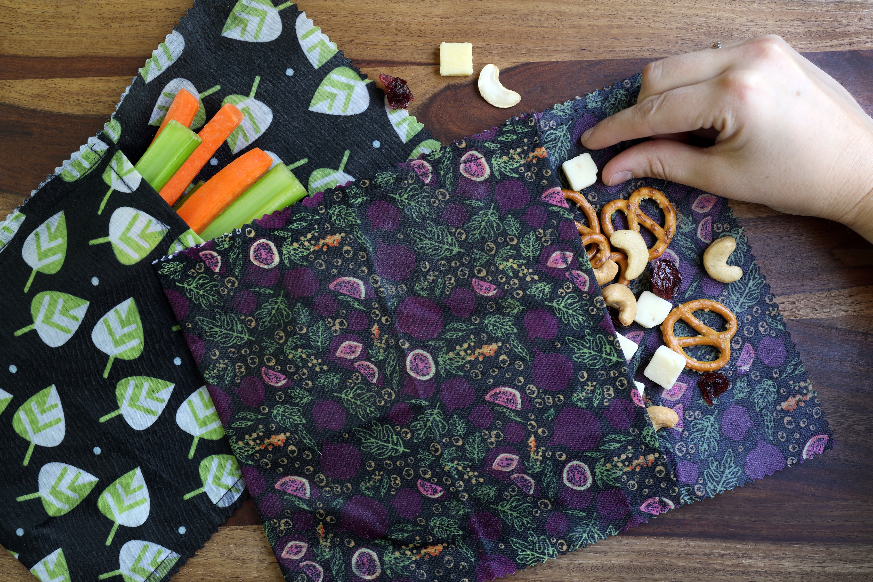 Hand about to pick up dried fruit from homemade snack pouch