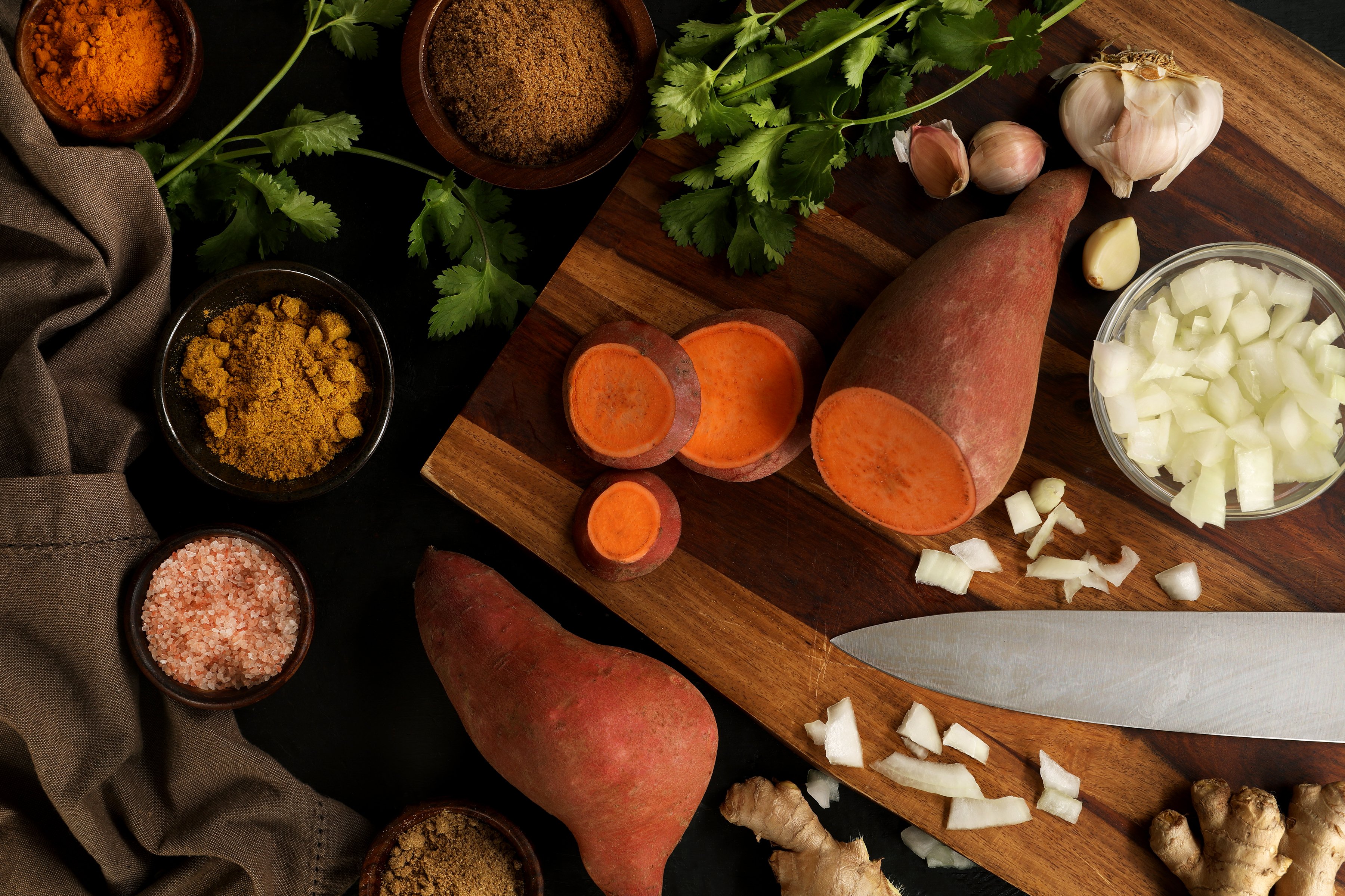Ingredients for making a vegan coconut curry and sweet potato soup from scratch. This creamy soup is delicious and healthful, using Indian spices like curry powder, cinnamon, and ginger. 