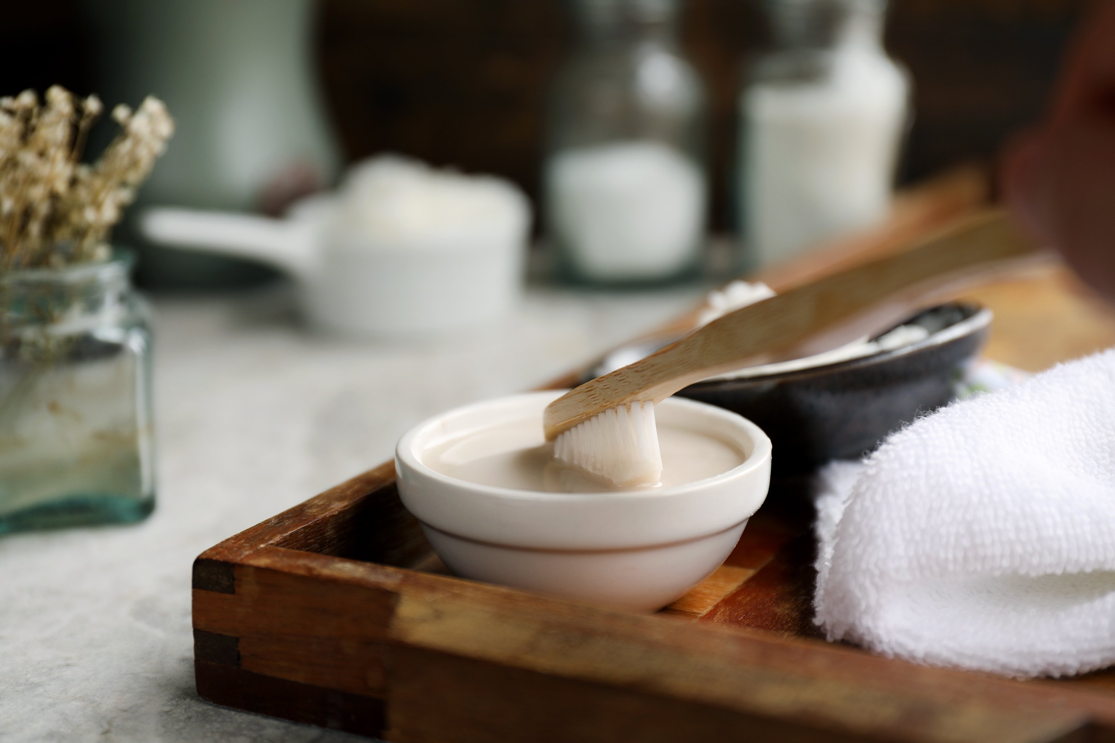 Wooden toothbrush being dipped into homemade toothpaste