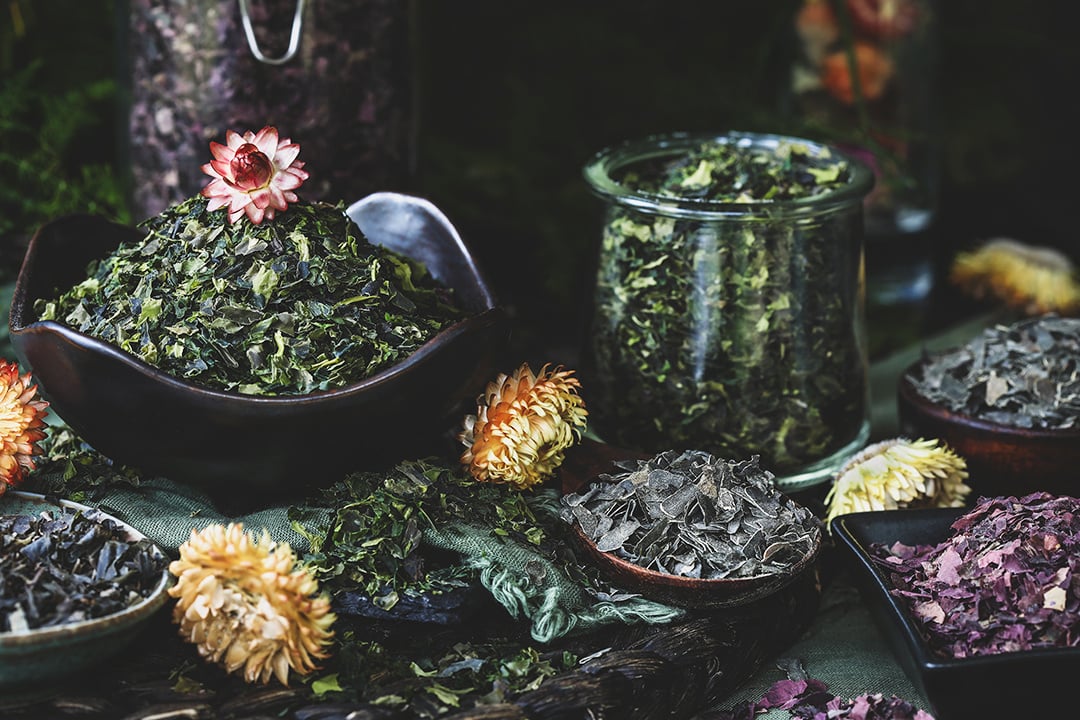 Small bowls of colorful dried seaweed flakes. 