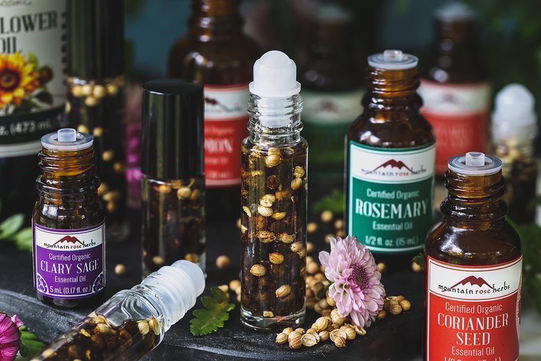 The home-made perfume bottle rolls into bottles filled with coriander seeds and berry- surrounded by essential oils used to make the recipe. 